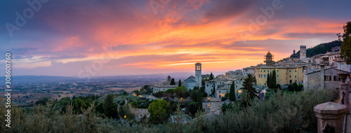 Sunset over Assisi, Umbria, Italy. Monumental, historic and romantic Italian countryside with roads, houses, churches. Skyline cityscape Assisi with hills of Umbria