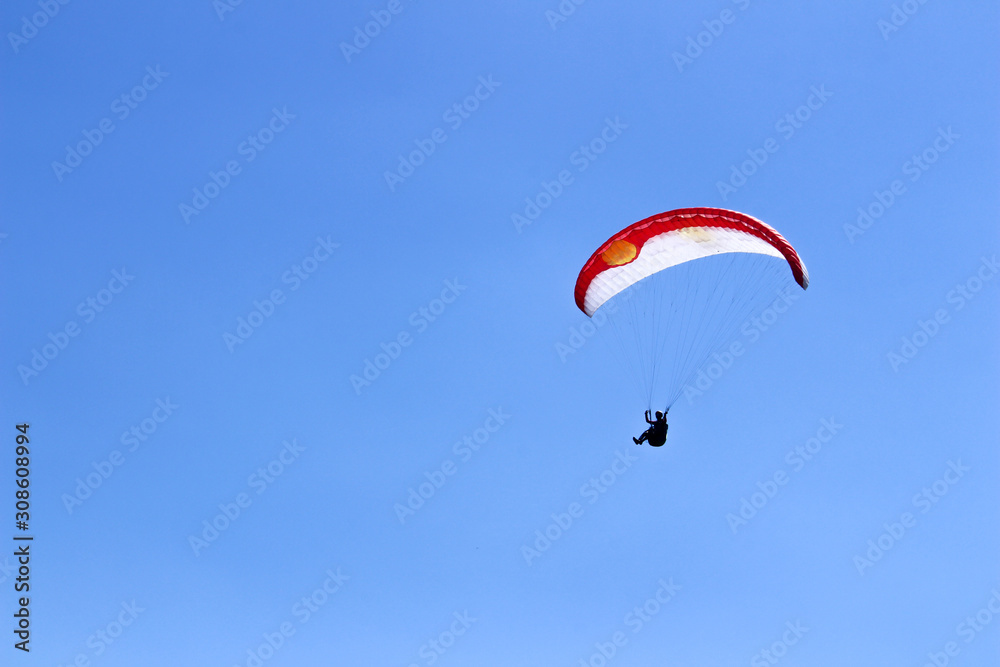 paraglider flying in blue sky on valleys landscape in Indonesia paraglider flying in blue sky on valleys landscape in Indonesia
