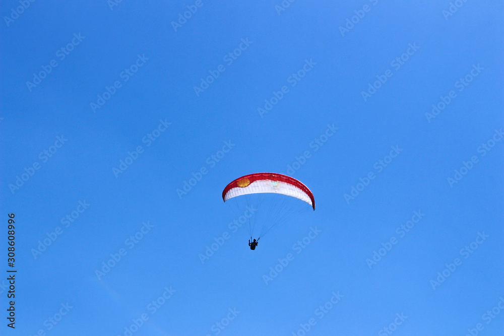 a paraglider flying in blue sky landscape in Indonesia a paraglider flying in blue sky landscape in Indonesia