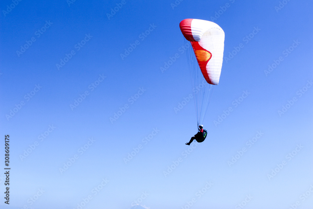 paraglider flying in blue sky on valleys landscape in Indonesia paraglider flying in blue sky on valleys landscape in Indonesia