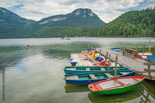 boats on a mountain lake ready to lend tourists for swimming on the blue water surface © edojob