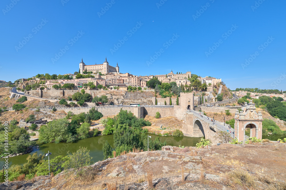 Landscape view of the old town of the medieval city of Toledo from above the Alcantara bridge over the Tagus river, Castilla la Mancha, Spain