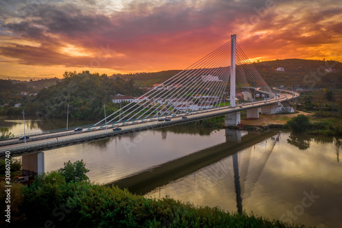 Cable-stayed bridge with semi-fan system steel structure Ponte Rainha Santa Isabel in Coimbra over the Mondego river during sunset