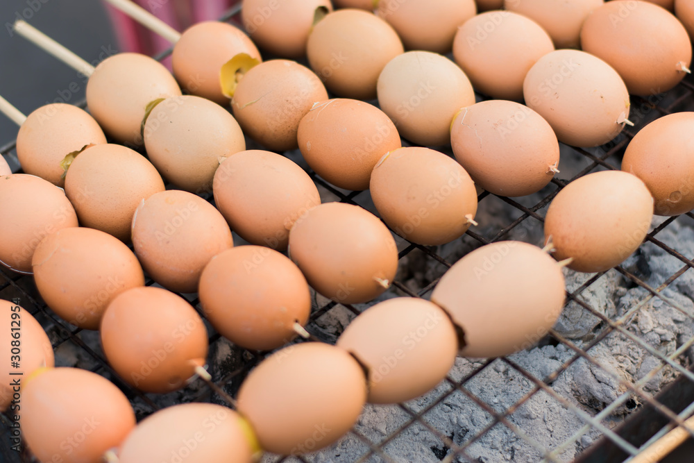 Grilled eggs skewered on a metal grill on a charcoal stove. Grilled eggs skewered on a metal grill on a charcoal stove.
