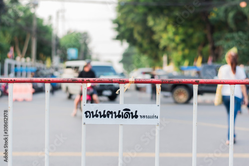 Fotografi Steel Barrier of an entrance sign attached to a sign that Khon Kaen Walking Street