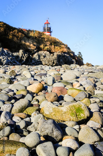 West Quoddy Head light along the boulder-strewn seashore at the most eastern point in the USA, Lubec, Maine photo