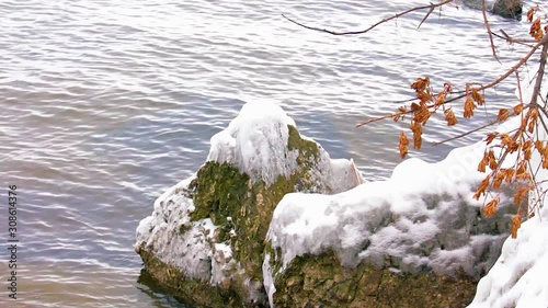 Melting ice on the river in the forest, white snow on the river banks