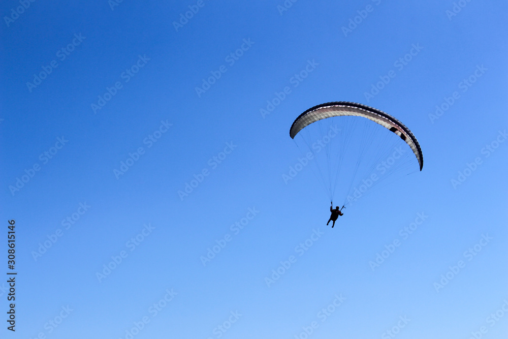 paraglider flying in blue sky on valleys landscape in Indonesia paraglider flying in blue sky on valleys landscape in Indonesia