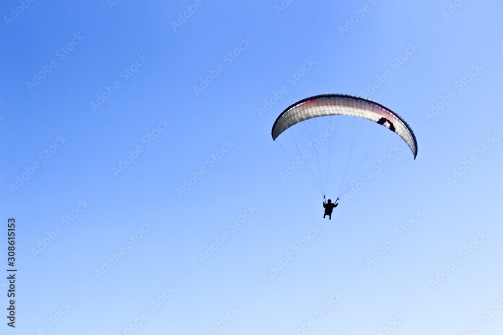 a paraglider flying in blue sky landscape in Indonesia a paraglider flying in blue sky landscape in Indonesia