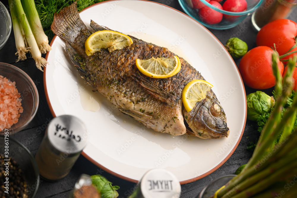 Stewed fish with lemons and fresh vegetables. Delicious and healthy food. Stewed fish with lemons and fresh vegetables. Delicious and healthy food.