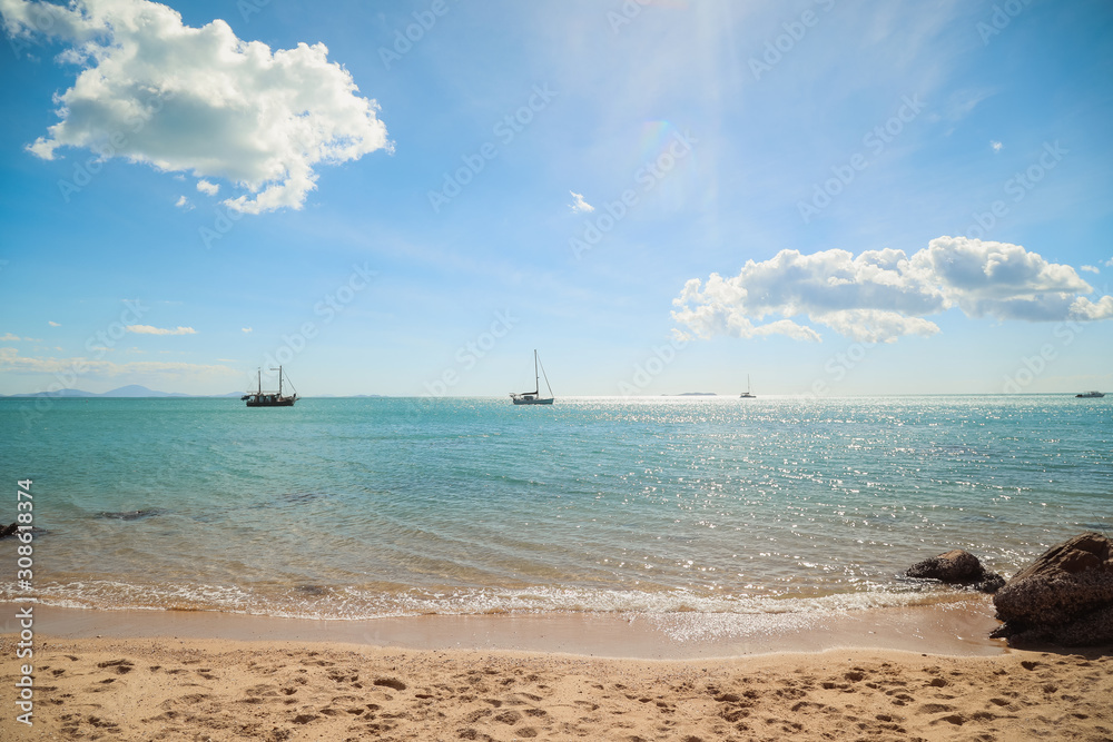 Fototapeta premium Seaside view with mountains in the distance, bright blue tropical waters of North Queensland off Cape Gloucester