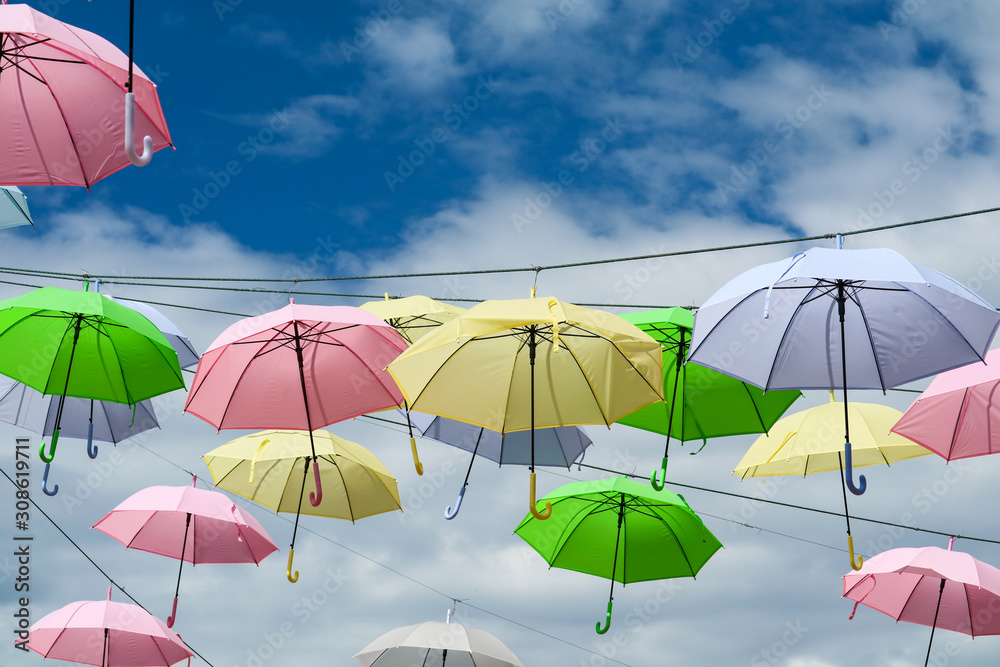 colorful umbrella line wire moving by wind on blue sky white cloud
