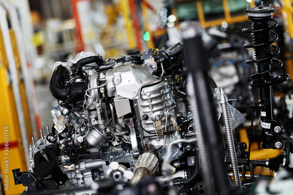 Fototapeta premium Car factory. An automobile internal combustion engine stands on the conveyor line of the production hall of an automobile plant.