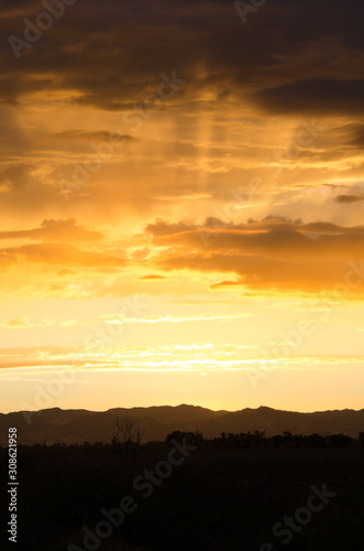 Sunset with clouds orange yellow light beams . © MikeFusaro