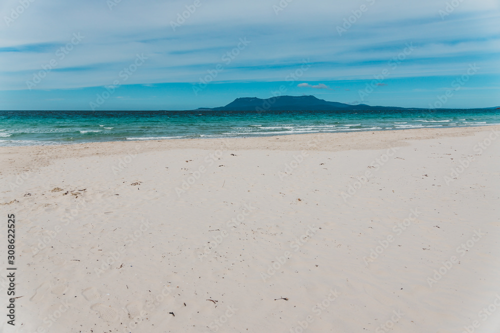 Spring beach in Tasmania, Australia looking pristine and deserted with white sand and turquoise water Spring beach in Tasmania, Australia looking pristine and deserted with white sand and turquoise water