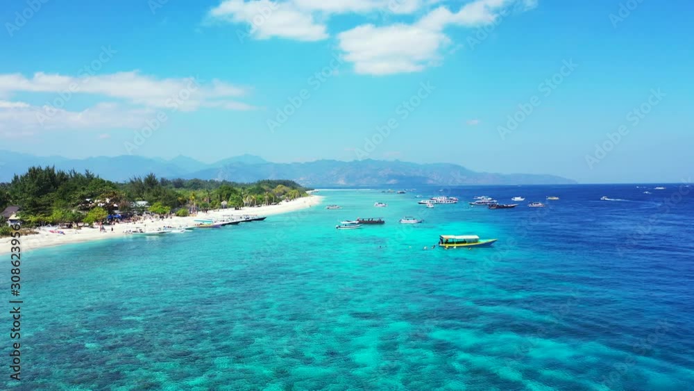 Island In Thailand - Boats Adrift Near The Shore Of A Tropical Island Surrounded By Clear Blue Sea Water With Coral Reef At The Bottom And Mountain In The Background - Wide Shot Island In Thailand - Boats Adrift Near The Shore Of A Tropical Island Surrounded By Clear Blue Sea Water With Coral Reef At The Bottom And Mountain In The Background - Wide Shot