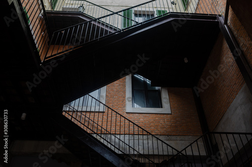 Modern design metal staircase with brick building.
