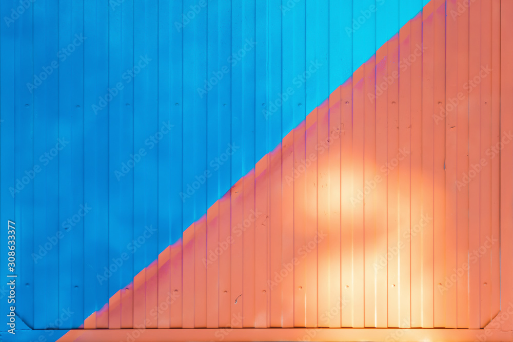 Background made of metal profile painted in blue and pink on the fence or container backlit by the sun Background made of metal profile painted in blue and pink on the fence or container backlit by the sun