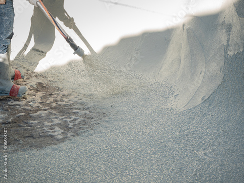 Man spraying cement during a swimming pool renovation.