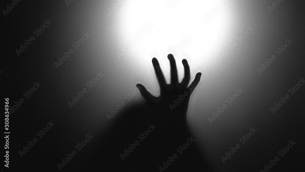 Abstract and spooky defocused hand. Silhouette of hand on mirror.