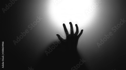 Abstract and spooky defocused hand. Silhouette of hand on mirror.