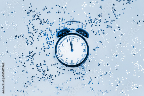 Star confetti with alarm clock concept blue toned
