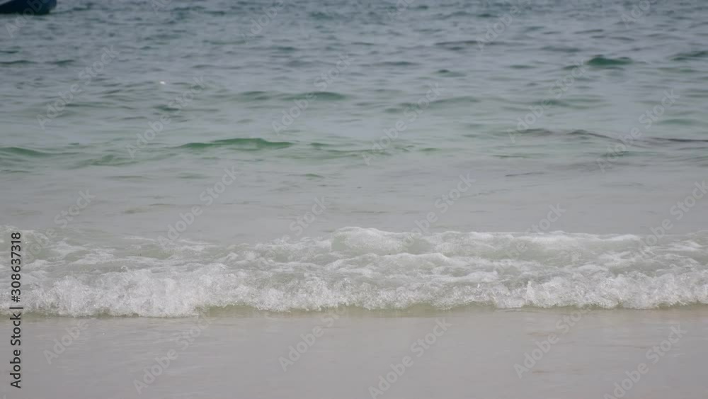 The sea is approaching the beach and a fishing boat floats in the sea. The sea is approaching the beach and a fishing boat floats in the sea.