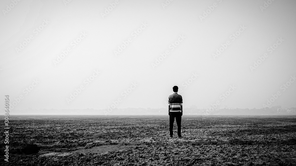Depressed man standing in the mid-desert Depressed man standing in the mid-desert