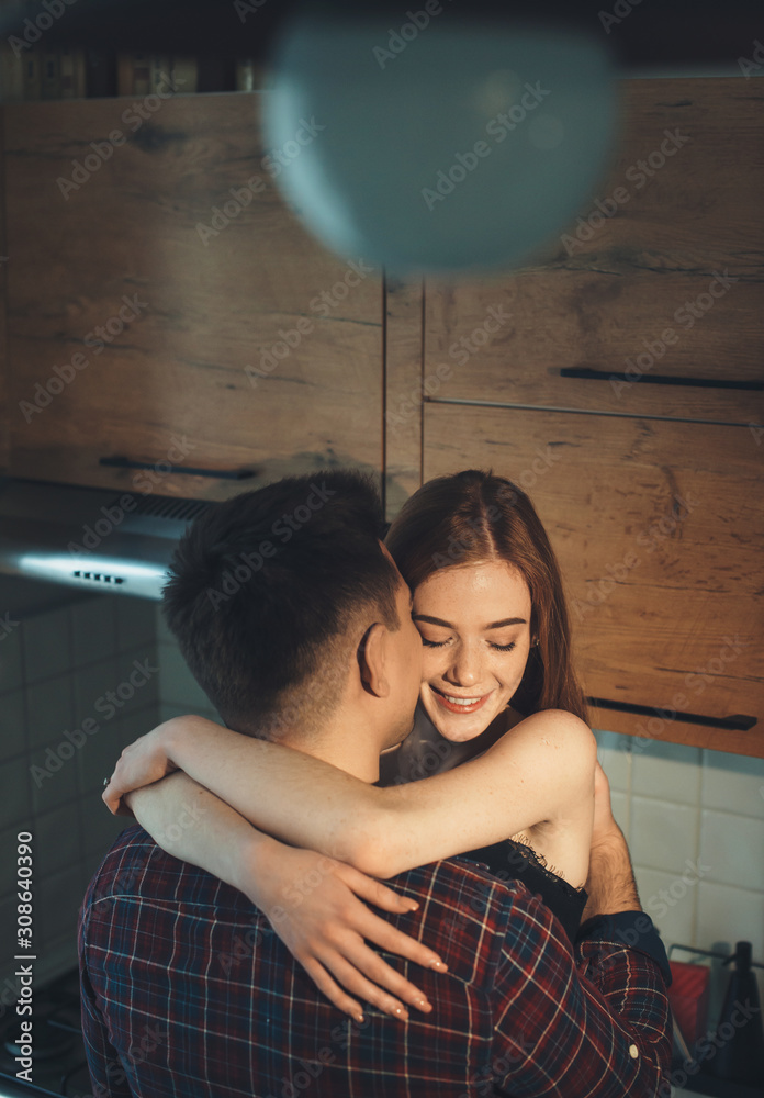 Φωτογραφία Top view portrait of a charming young couple embracing in the kitchen in the morning at their home