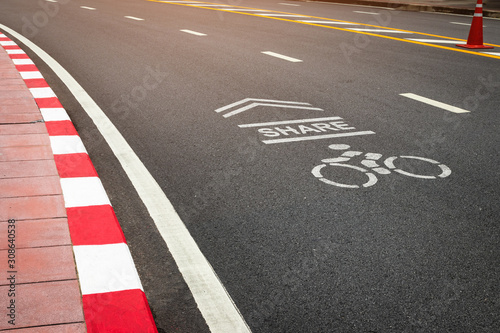The symbol of the bike lane on the street. Sign on the cycling way meaning please share lane for bikers. © pjjaruwan