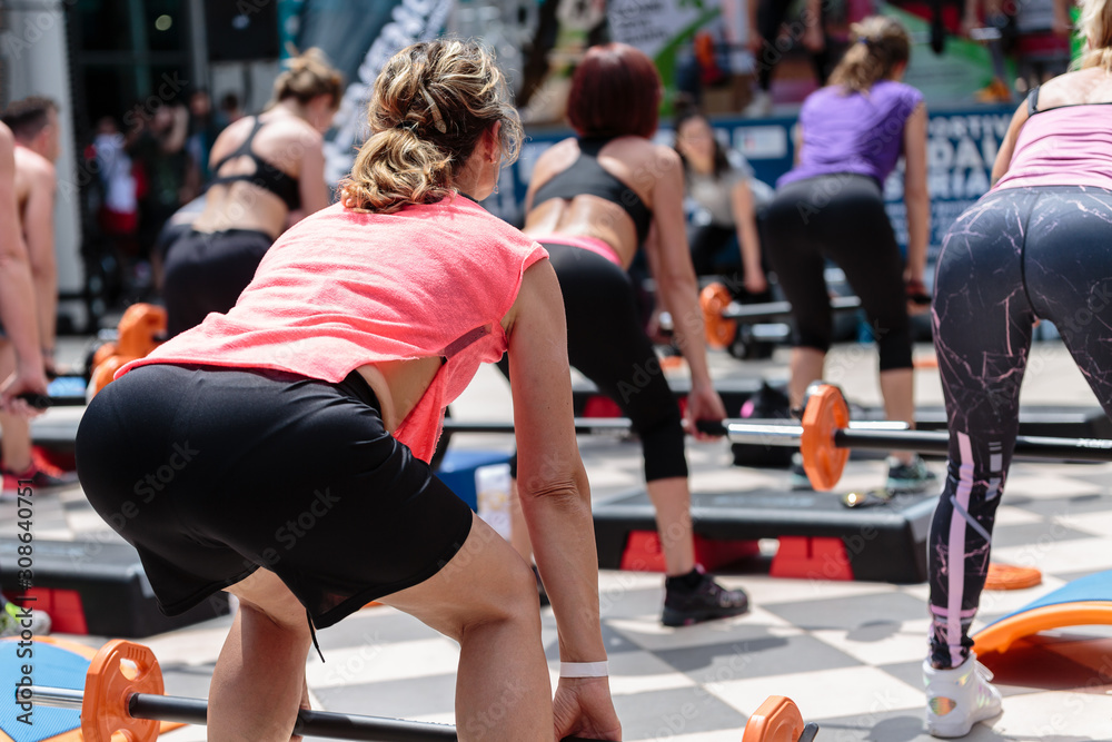 Fitness Workout in Gym: Woman doing Exercises in Outdoor Class with Barbell and Weights Fitness Workout in Gym: Woman doing Exercises in Outdoor Class with Barbell and Weights