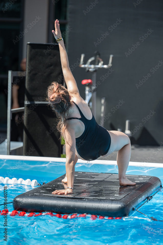 Girl Doing Exercises on Floating Fitness Mat in an Outdoor Swimming Pool