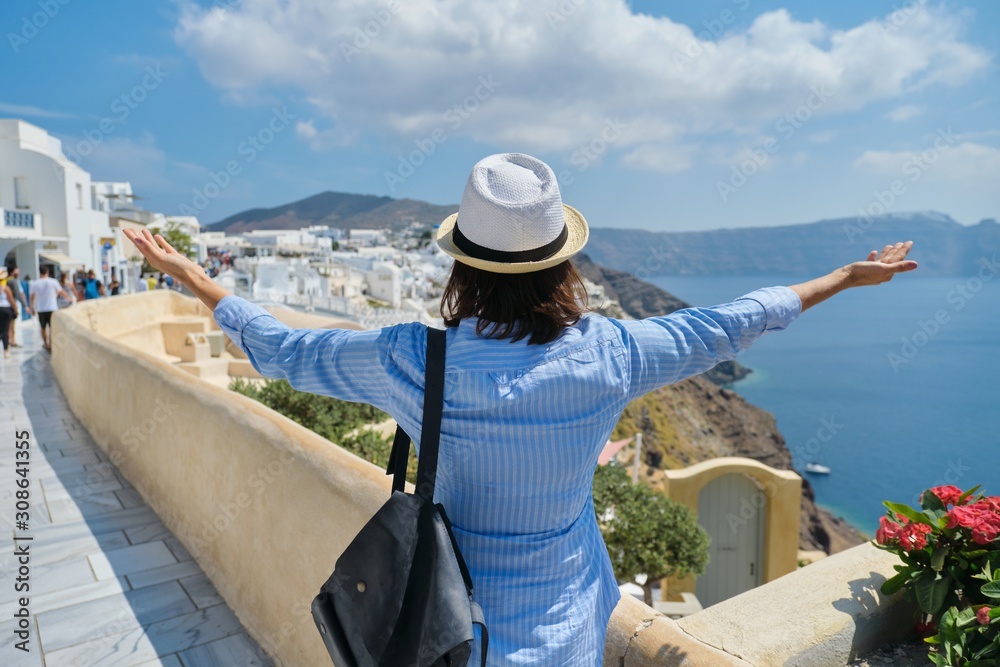 Happy woman tourist with arms raised up, Greek island Santorini, Oia