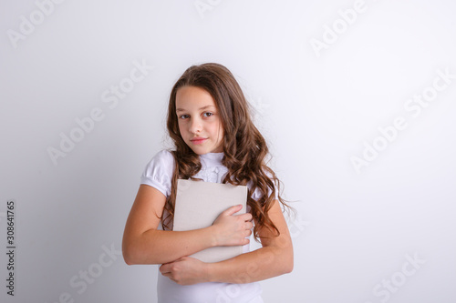 Teenage girl with a book in her hands on a white background. Shows emotions joy, surprise, sadness.