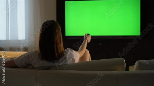 Girl watching TV with a green screen