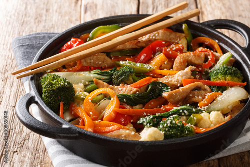 Healthy stir fried pork with different vegetables close-up in a pan. horizontal