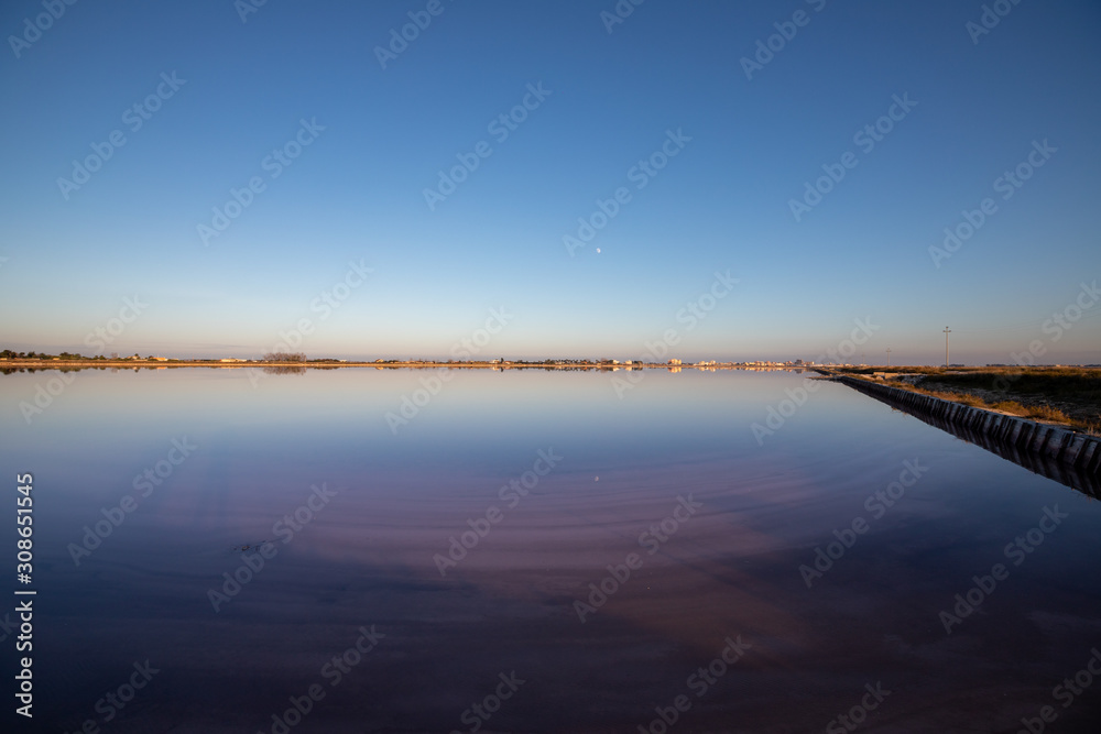 Nature reserve Saline Margherita di Savoia, Apulia, Italy: The salt pan. Salt flats area for sea salt production. Coastal ecosystem on Adriatic sea. Red waters colored by alga Dunaliella salina