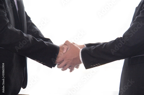 Two businessmen are holding hands with both hands. To congratulate another.On white background.