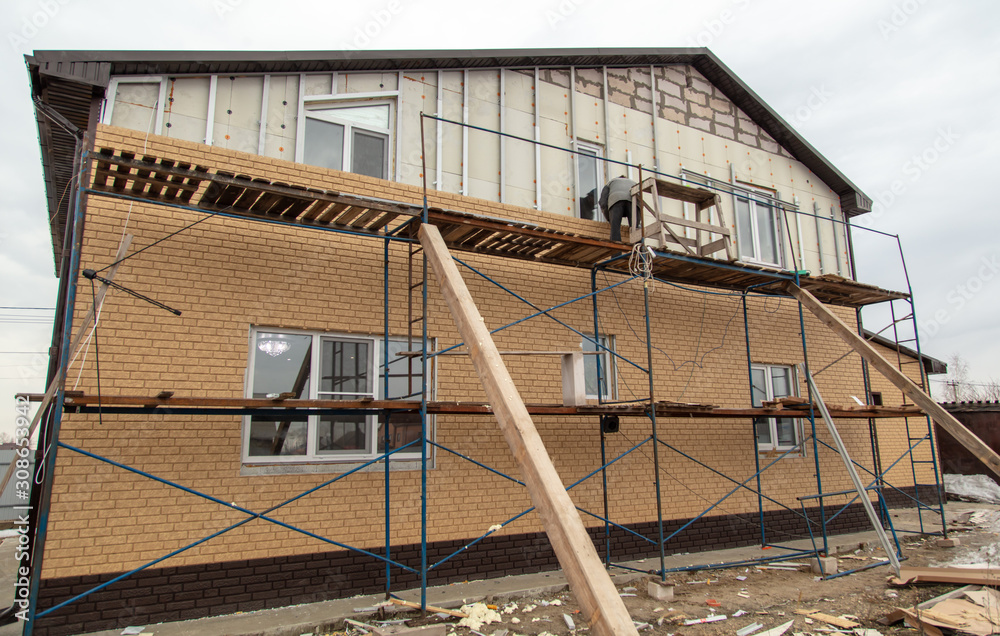 Naklejka premium Installation of siding on the walls of the house