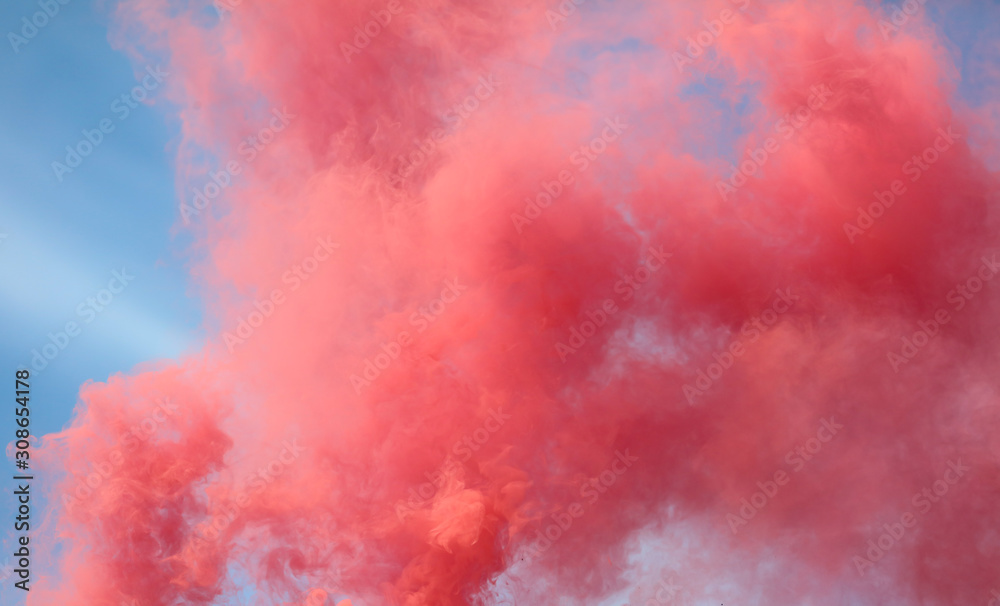 Naklejka premium Red smoke on a blue sky