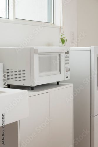 白物家電（白いミニ冷蔵庫と電子レンジ）のあるミニキッチン 白 キッチン シンプル 白背景 背景 素材 新生活 一人暮らし 家電 文字スペース コピースペース 余白 グラフィック素材