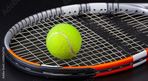 tennis racket and ball on black background © Sergejs Katkovskis