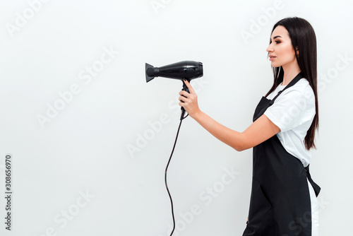 Beautiful professional hair stylist holding blow dryer