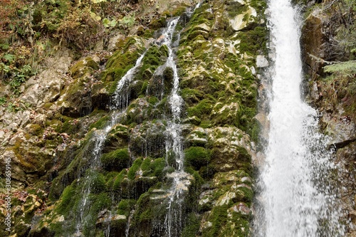 Little natural waterfall in the forest in autumn.
