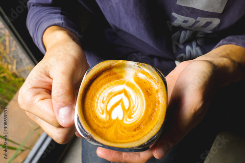 Close-up of man holding a hot latte coffee