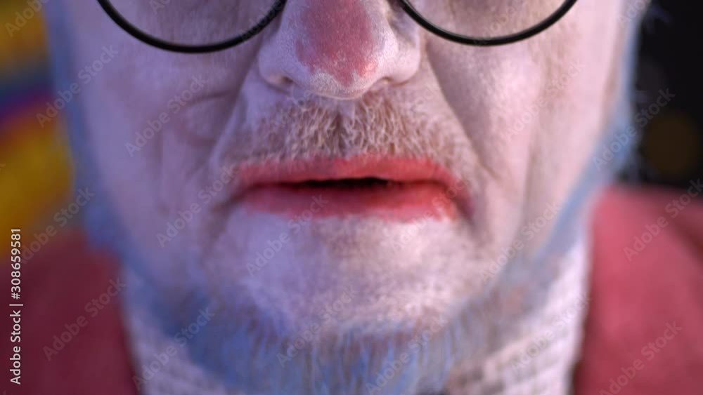 elderly mime man in large glasses with blue hair and beard in bright pink jacket and tie in white gloves. clown does makeup on face. White face, blue hair, red lips. Happy clown elderly mime man in large glasses with blue hair and beard in bright pink jacket and tie in white gloves. clown does makeup on face. White face, blue hair, red lips. Happy clown