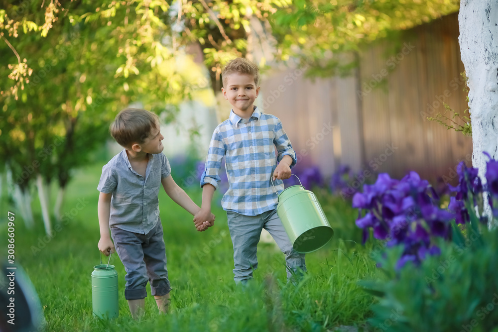 Fototapeta premium Two handsome brothers having fun while sitting outside in garden.