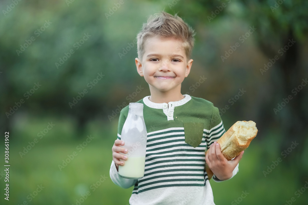 Little boy with girl drink milk and eat a loaf of bread on a haystack in a village at sunset. Little boy with girl drink milk and eat a loaf of bread on a haystack in a village at sunset.