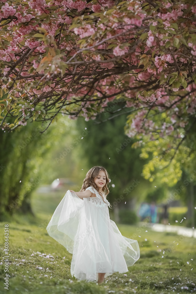 A girl with long white hair in a white dress like a bride walks in the Park alone.