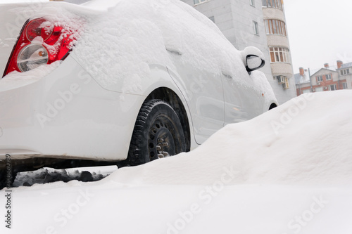 Snowfall in the city cars in the snow on the street